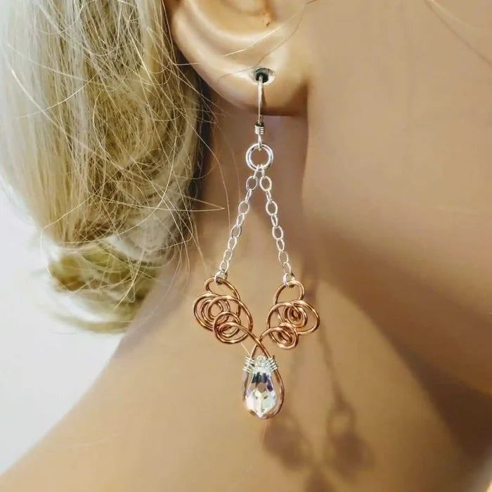 Wire Sculpted Crystal Drop Chandelier Angel Wing Earrings hanging elegantly on a mannequin ear, showcasing their unique design.