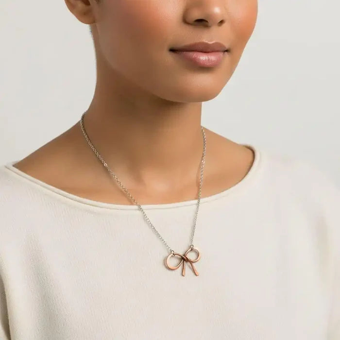 Model wearing a Wire Wrapped Copper Bow Tie Silver Chain Necklace with a hand-sculpted copper pendant.