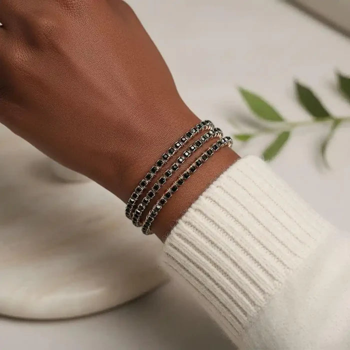 Wire Wrapped Copper Silver Black Crystal Rhinestone Bangle worn on a wrist with a sweater.