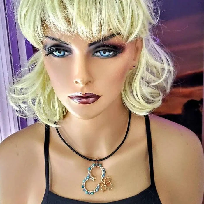 Wire Wrapped Copper Turquoise Heart Infinity Charm Necklace displayed on a mannequin with blonde hair and a stylish outfit.