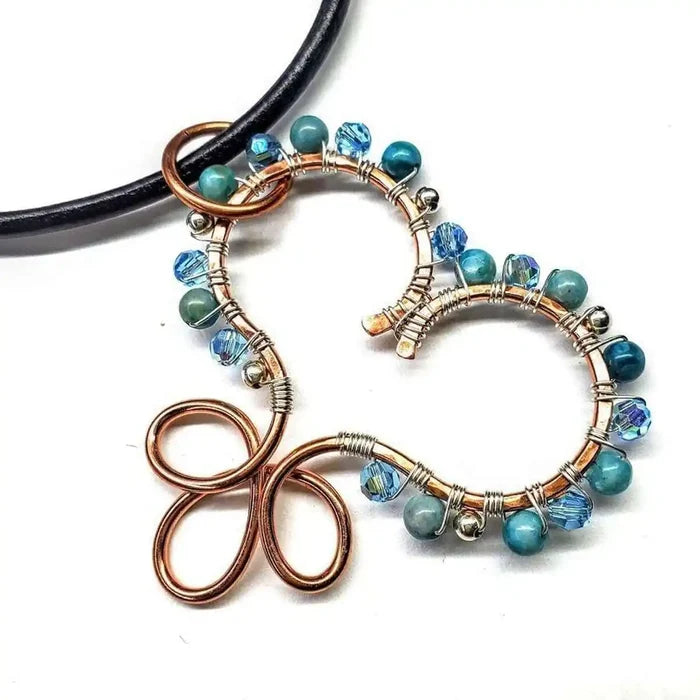 Wire Wrapped Copper Turquoise Heart Infinity Charm Necklace with turquoise beads and Swarovski crystals on a black cord.