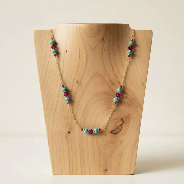 Wire Wrapped Gold Filled Pink Turquoise Gemstone Necklace displayed on a wooden bust, showcasing vibrant turquoise and fuchsia beads.