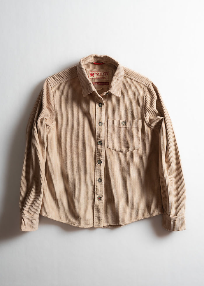 Tan corduroy button-up shirt with a chest pocket, displayed on a white background, showcasing its texture and design.