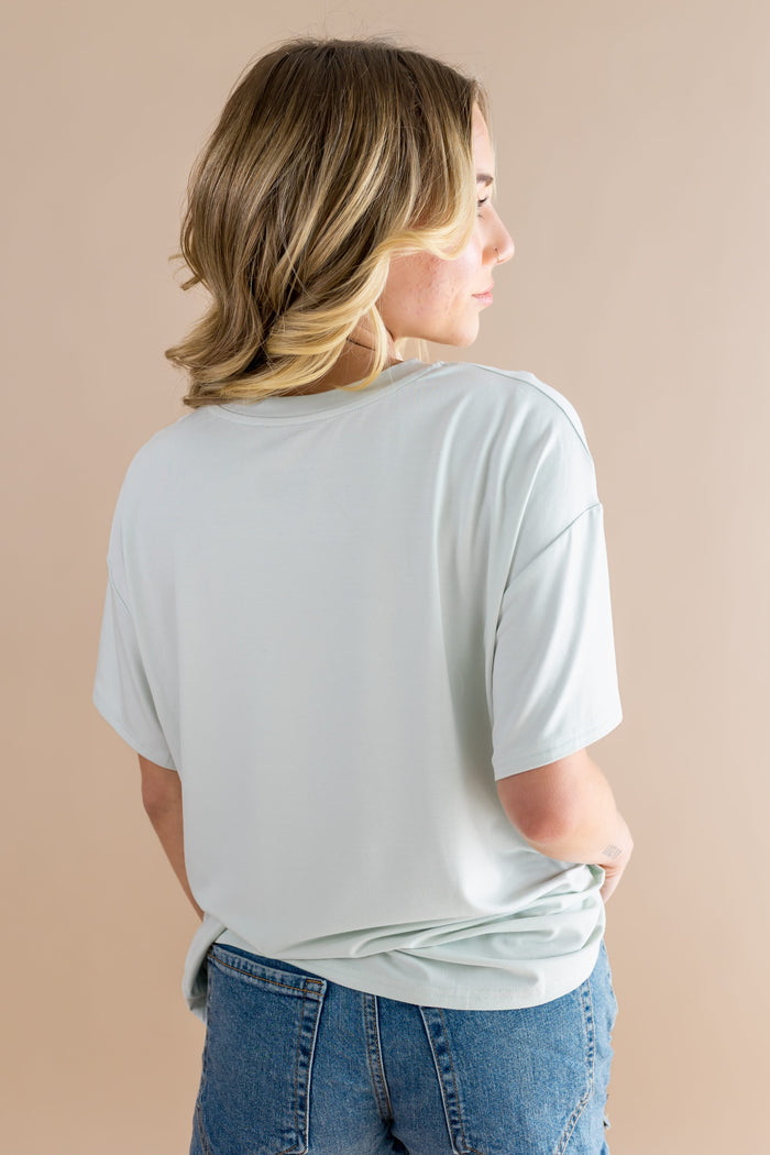 The back of the Women's Graphic Tee in Winnie the Pooh on Dew
 showing the light green shirt on a female model