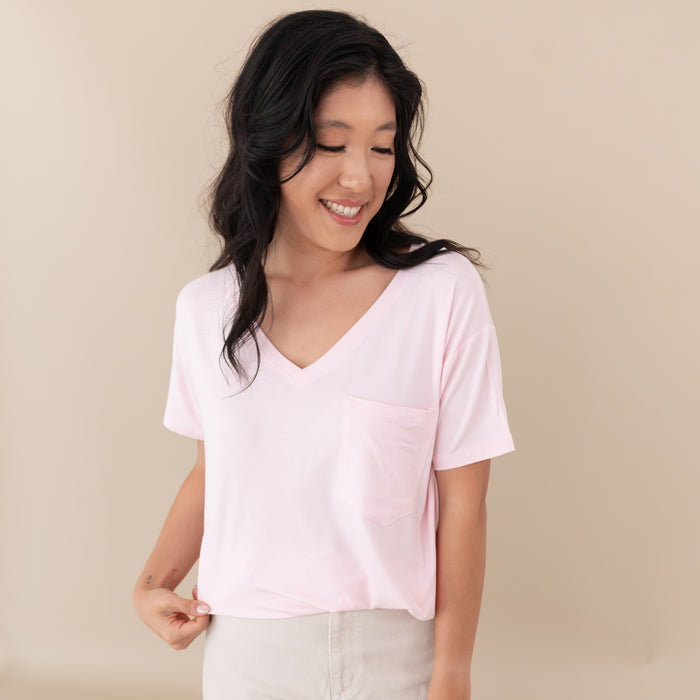 Woman modeling Women’s Relaxed Fit V-Neck in Sakura against a tan backdrop