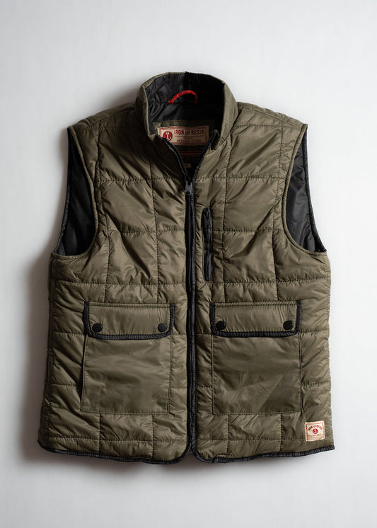 Olive green quilted vest with black trim, front zipper, and buttoned pockets. Features "Iron and Resin" label inside.