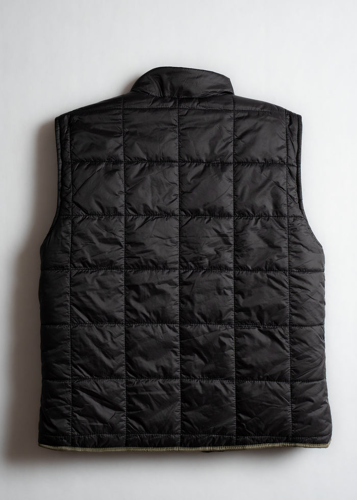 Black quilted vest with a high collar, viewed from the back, showcasing its square stitching pattern on a plain background.