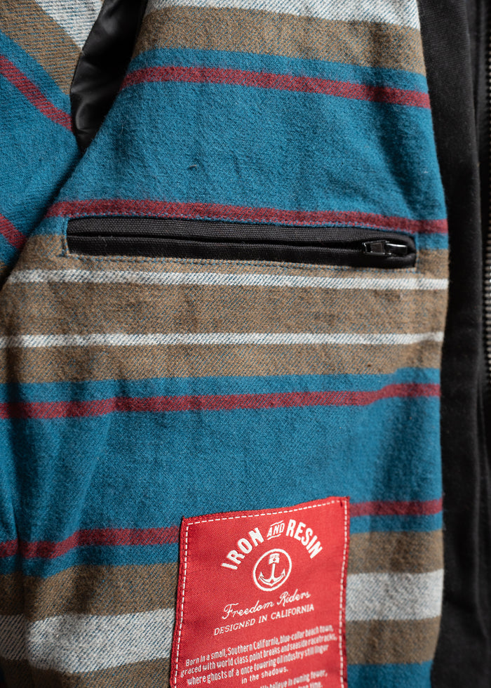 Striped fabric with a zippered pocket and red Iron and Resin label, designed in California, showcasing a rugged, vintage style.