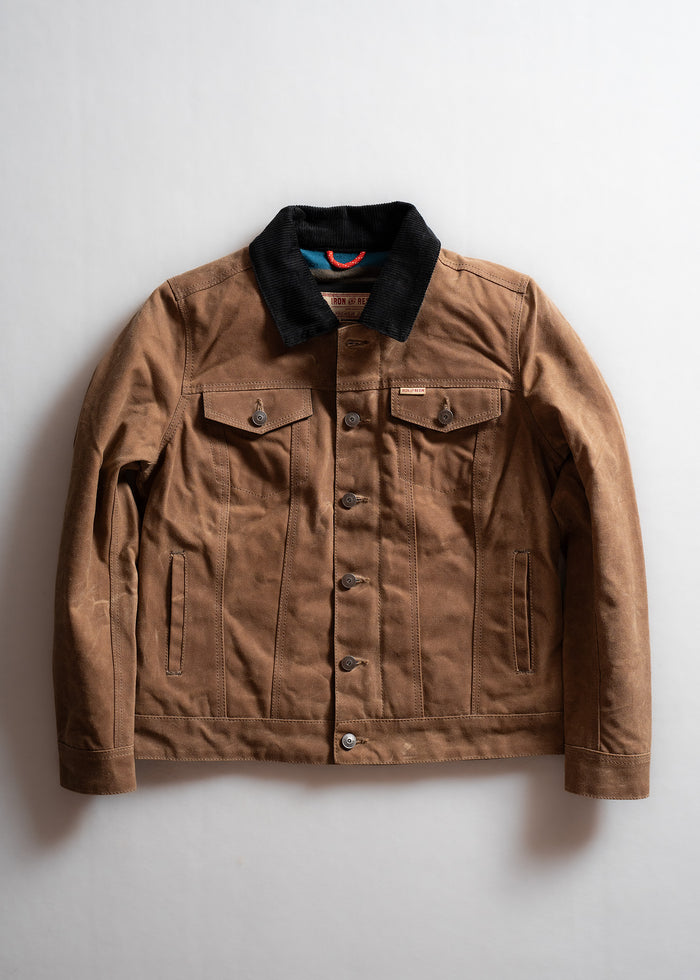Brown canvas jacket with black corduroy collar, buttoned front, and chest pockets, displayed on a light background.
