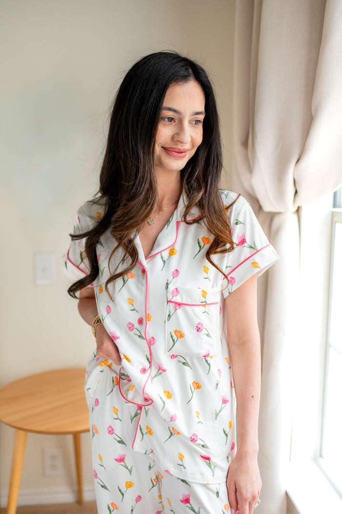 Close up of model wearing the Women's Short Sleeve Cropped Pajama Set in Tulip standing beside  a window