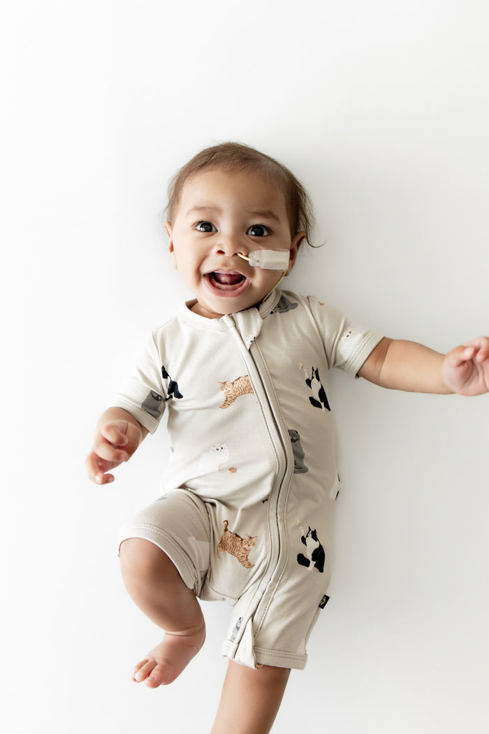 Close up of the Zipper Shortall Romper in Fluffy Cat shown on an infant